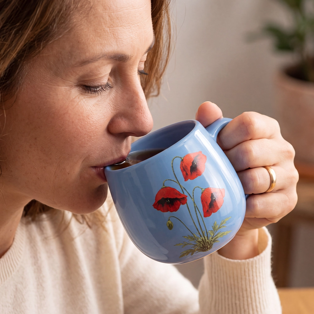 Woman drinking coffee from Forever Remembrance Mug